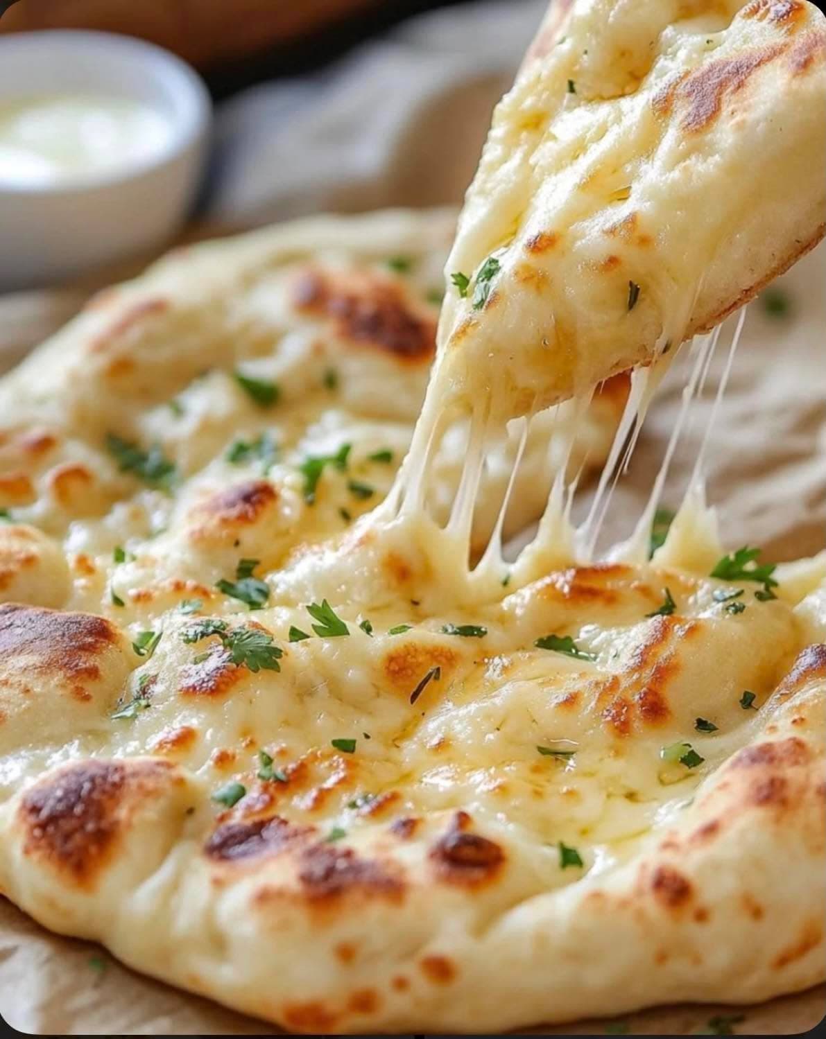 Cheese Naan — Naan stuffed with melted cheese and fresh herbs, baked until bubbling.