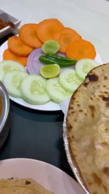Fresh salad platter served alongside paratha